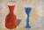 Painting of a red jar and blue goblet simply rendered as blocks of colour against agrey and yellow background
