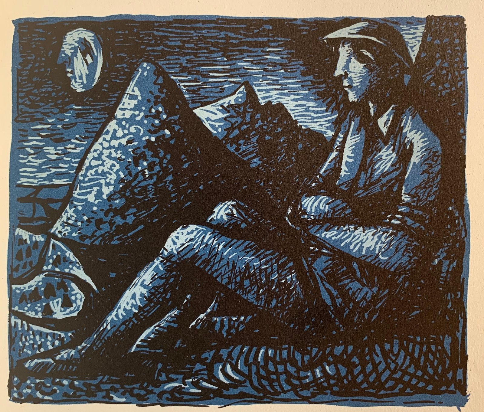 A young man sits in a field with mountain peaks in the background and a moon with a face to the left.