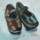 A painting of a piar of black single strap shoes.